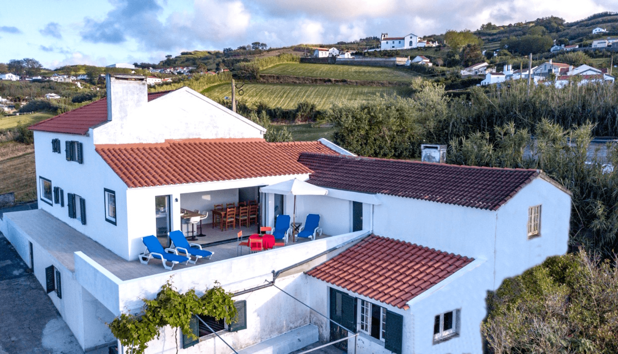 The house and its terraces from the air, village on the hill behind